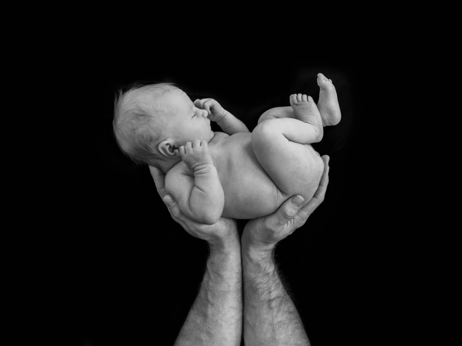 newborn baby in dads hands